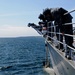 Sailors watch USS Normandy's anchor rise