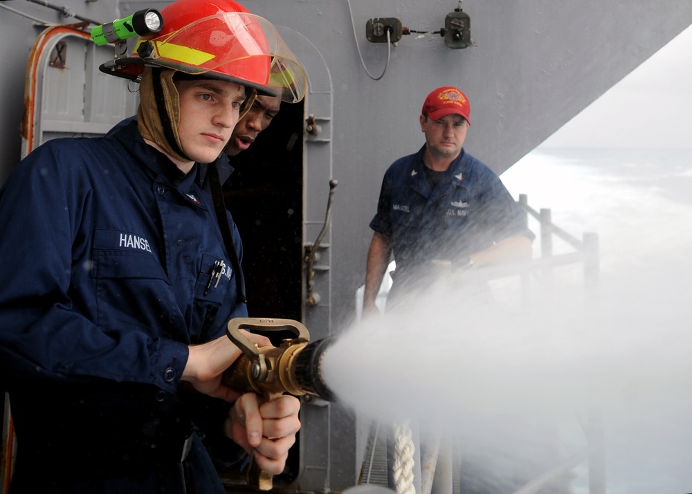 USS George H.W. Bush sailor holds fire hose