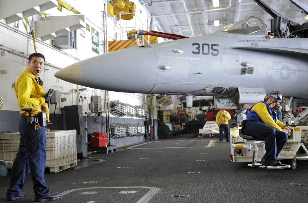 Sailor directs F/A-18C Hornet into hangar bay