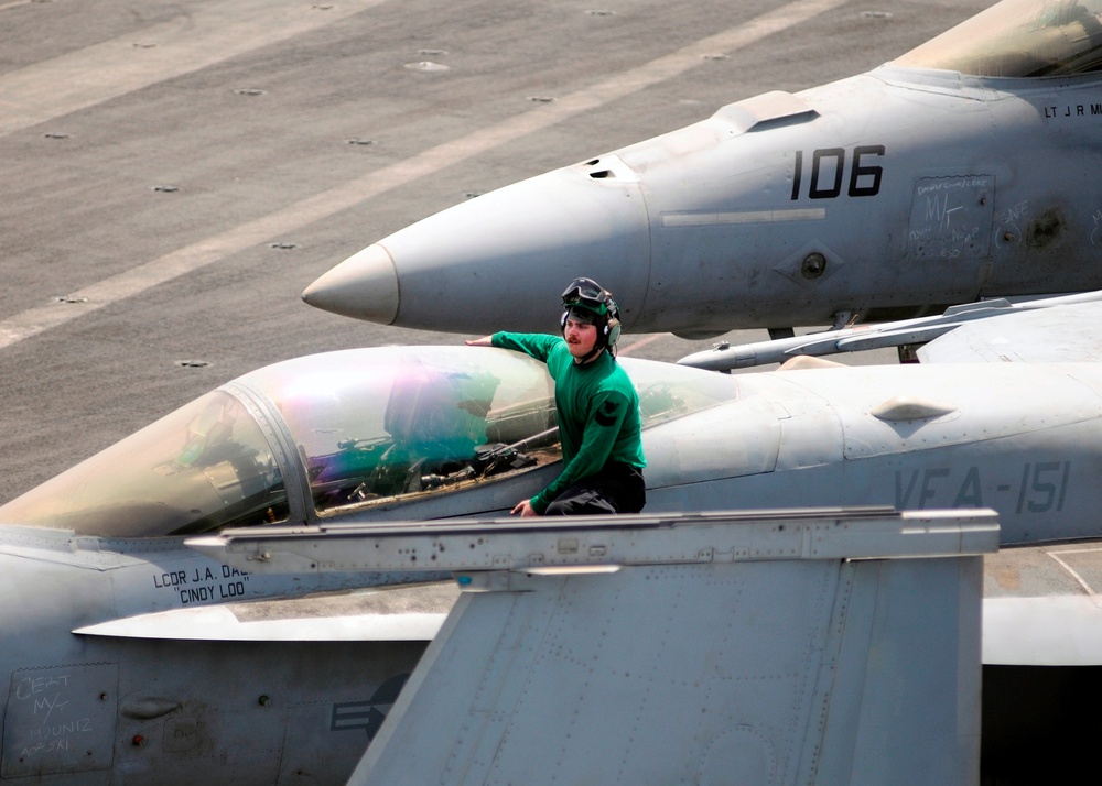 Sailors perform maintenance on F/A-18C Hornet