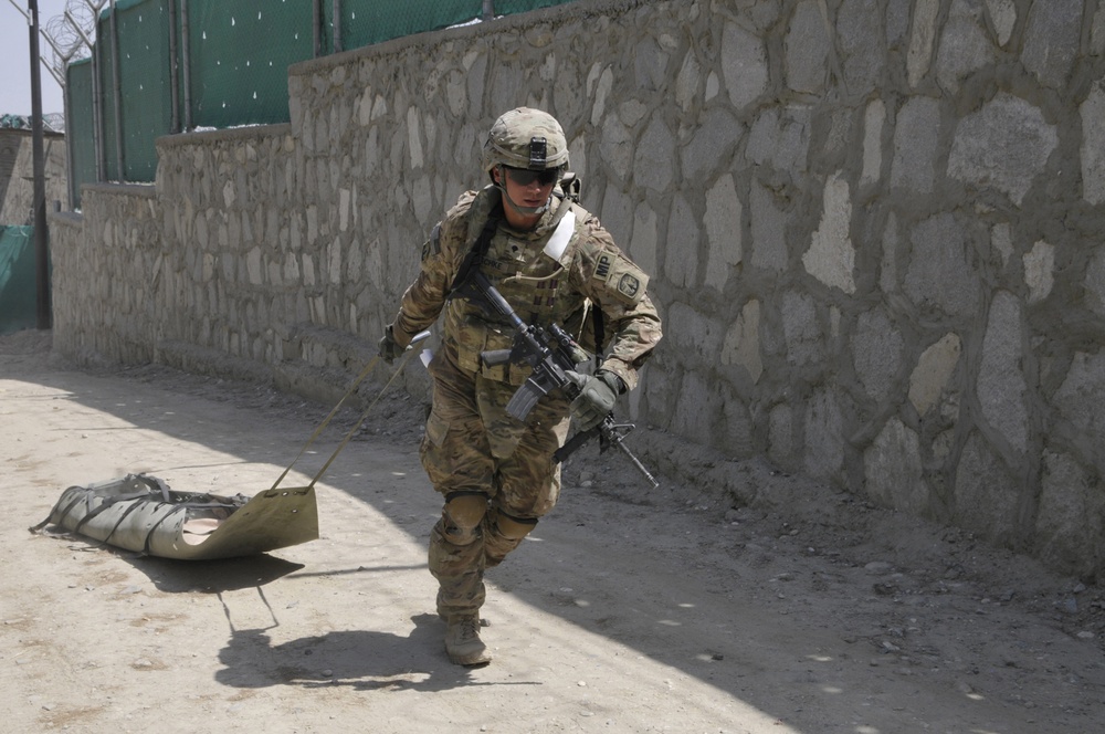 Spc. Kirk Peschke pulls a skedco litter up a hill