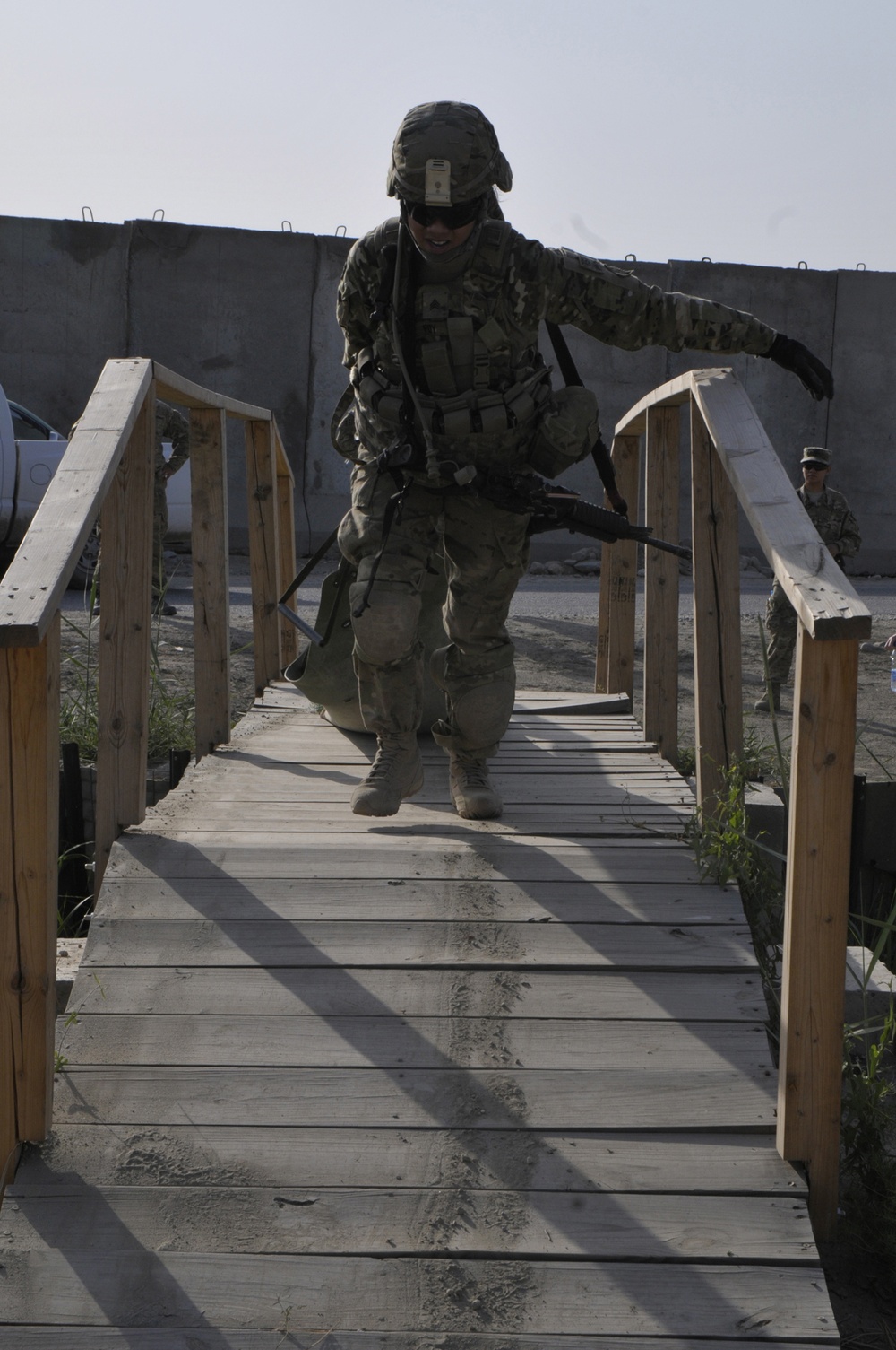 Sgt. Celina Foy drags a skedco litter across a bridge