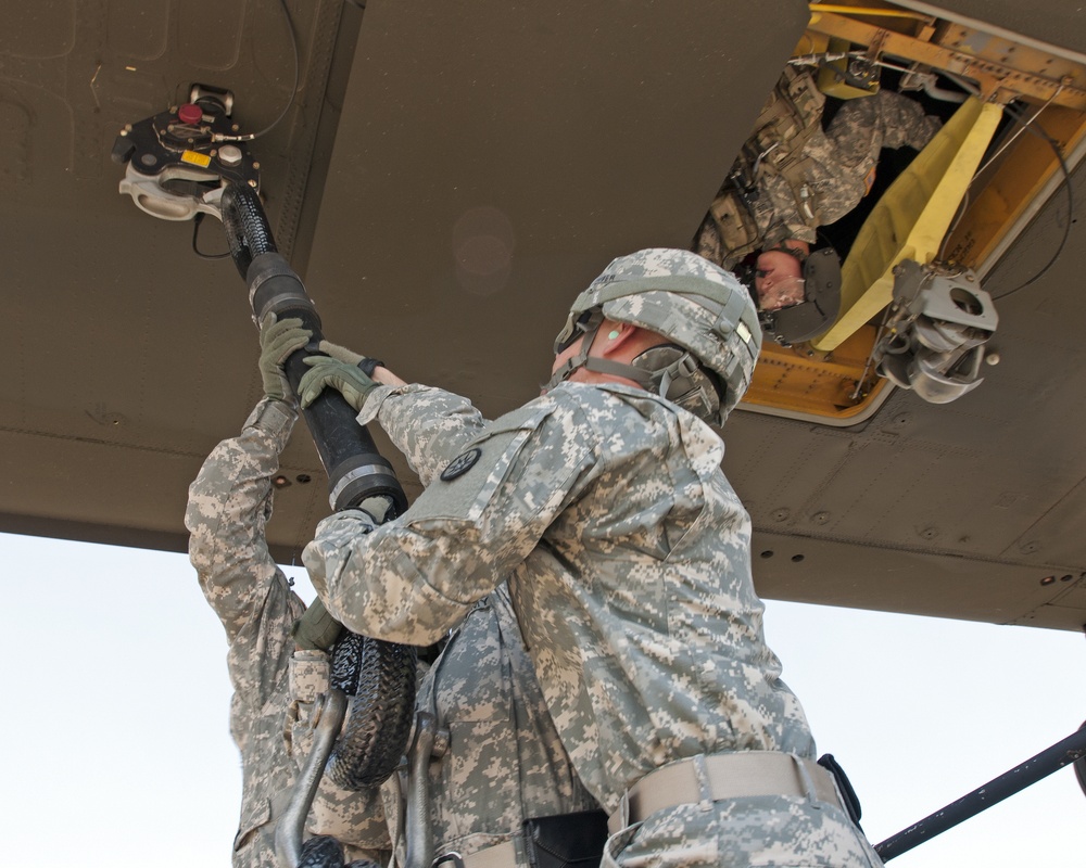 316th ESC soldiers attach the rope to a CH-47 CHinook