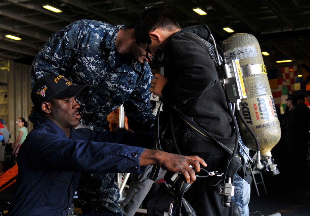 USS Carl Vinson sailor helps guest try on gear