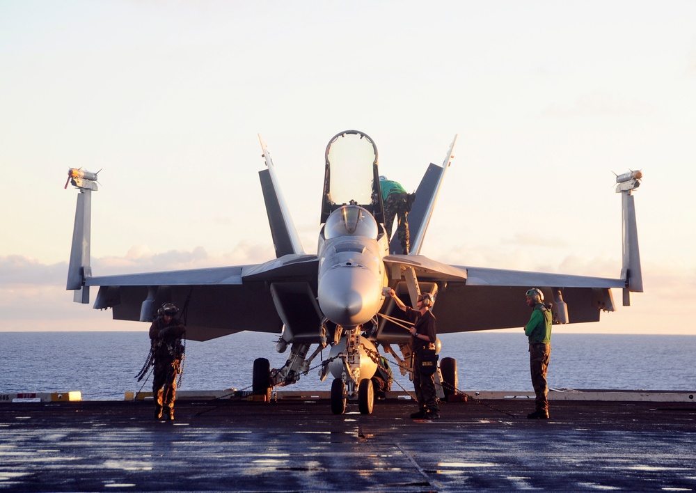 Perform maintenance on an F/A-18E Super Hornet