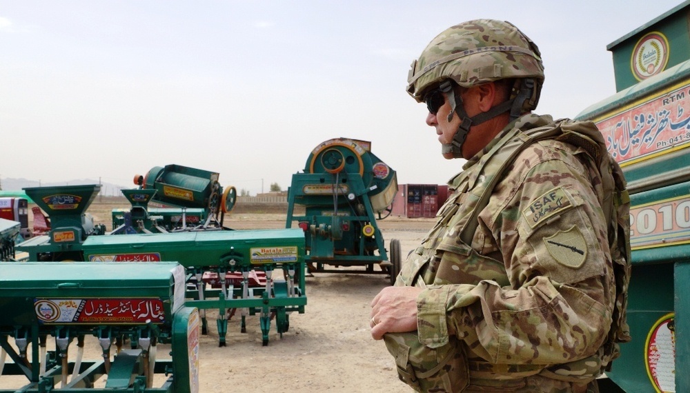 Civilian surveys farm equipment for Afghanis