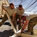 Soldiers work together to assemble a building frame in Afghanistan