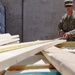 Soldier measures wood for a building in Afghanistan