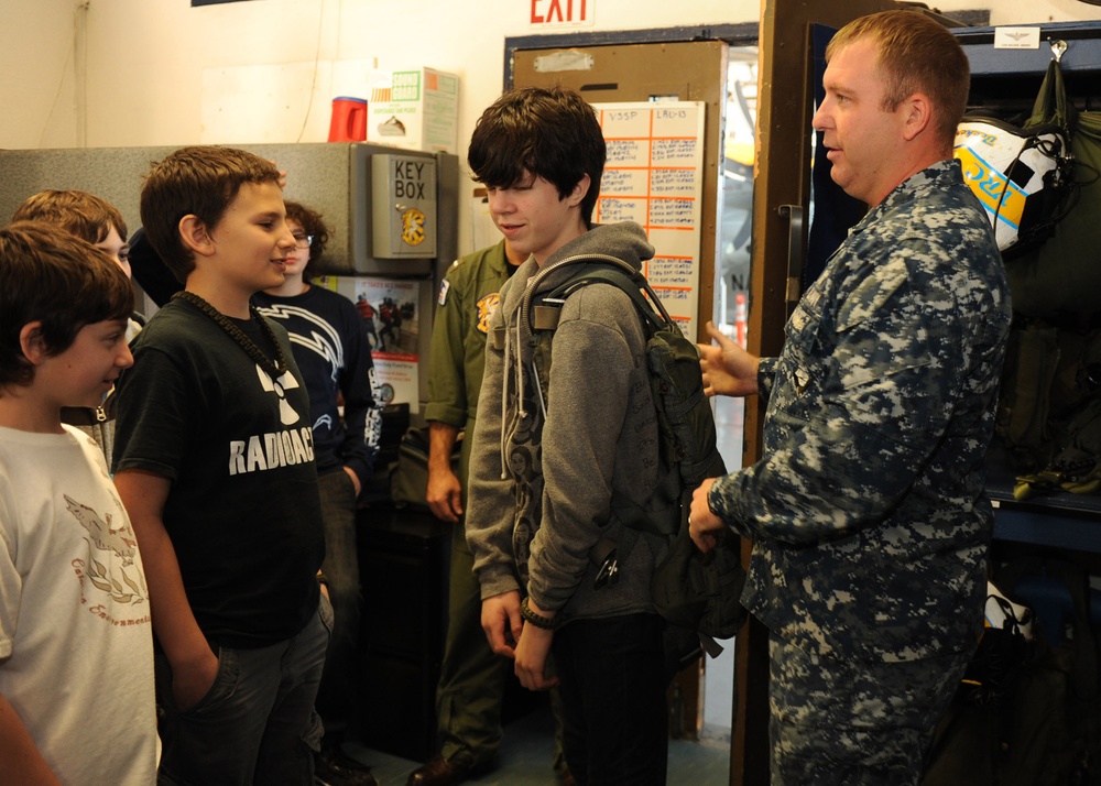 Sailor shows how a flotation device works to students