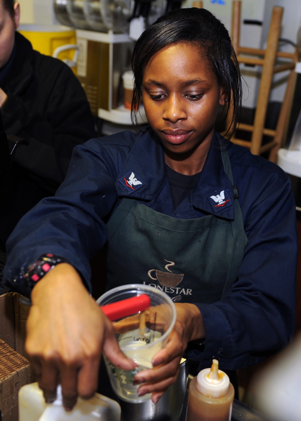 USS George H.W. Bush sailor pours cup of coffee