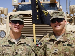 Two Kentucky soldiers pose together with their unit flag in southern Afghanistan
