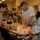 Patriot Exercise 2012 Military personnel are conducting a medical training exercise using a realistic patient simulator mannequin. Multiple service members in U.S. Army and Air Force uniforms are practicing emergency medical procedures around a table-mounted simulation dummy connected to various medical devices. The setting appears to be an indoor training facility with additional personnel observing in the background.