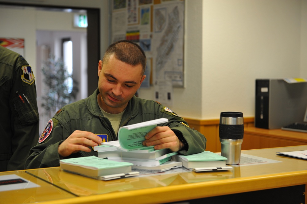 Fighter Squadron pilot reads flight publication before pre-flight briefing