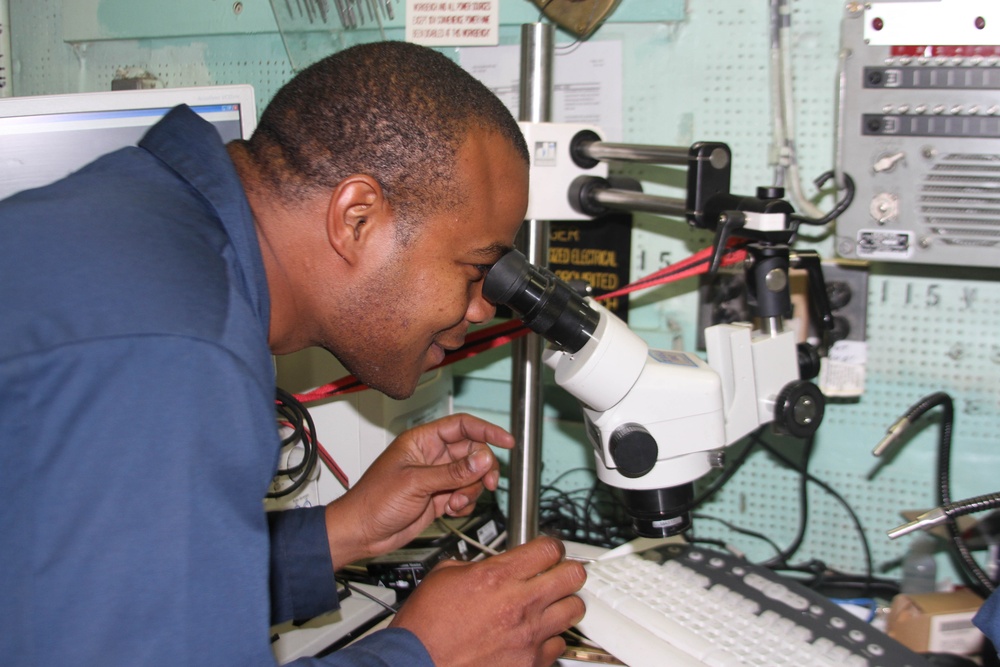 USS Taylor sailor works on circuit card