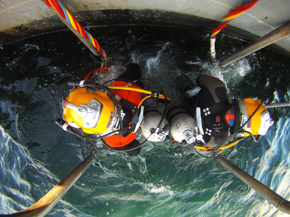 US Navy divers search for the remains of five unaccounted for service members from 1942