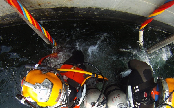 US Navy divers search for the remains of five unaccounted for service members from 1942