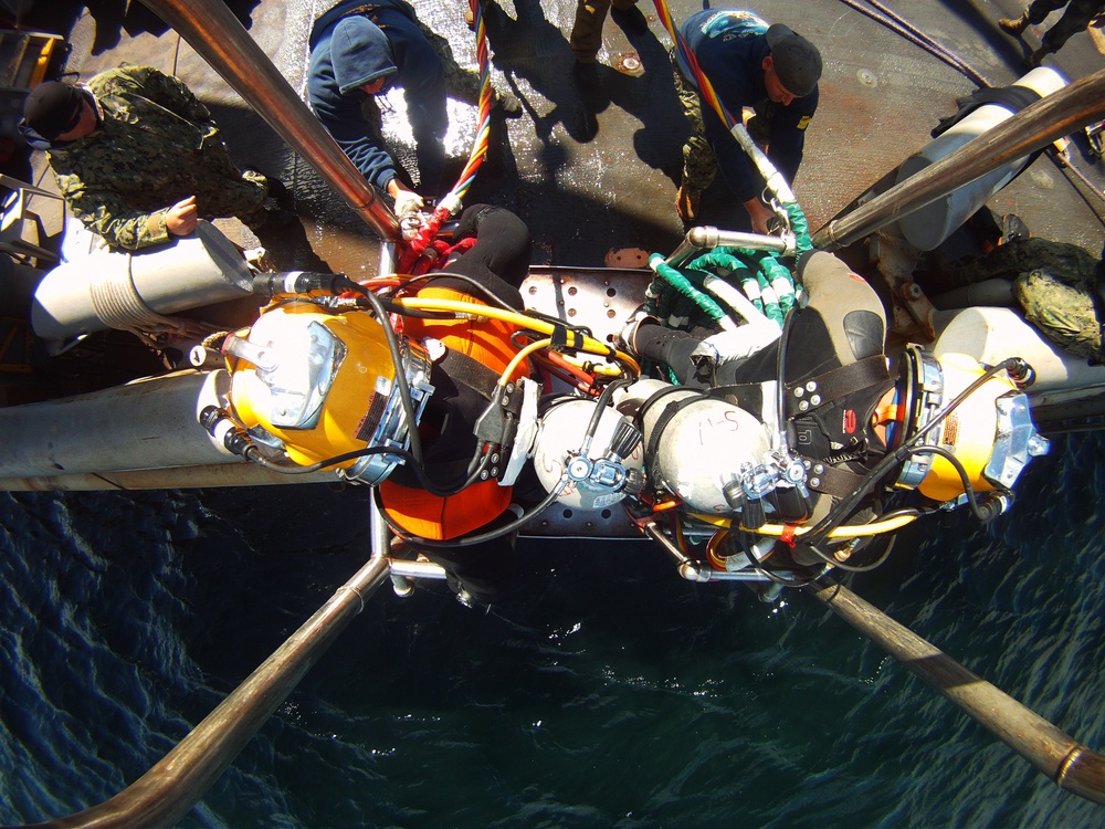 US Navy divers search for the remains of five unaccounted for service members from 1942