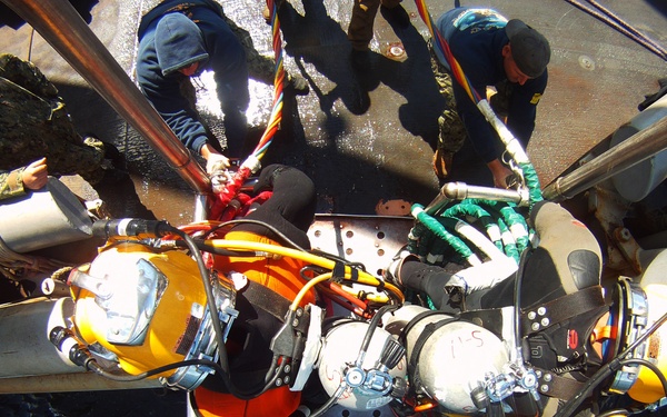US Navy divers search for the remains of five unaccounted for service members from 1942
