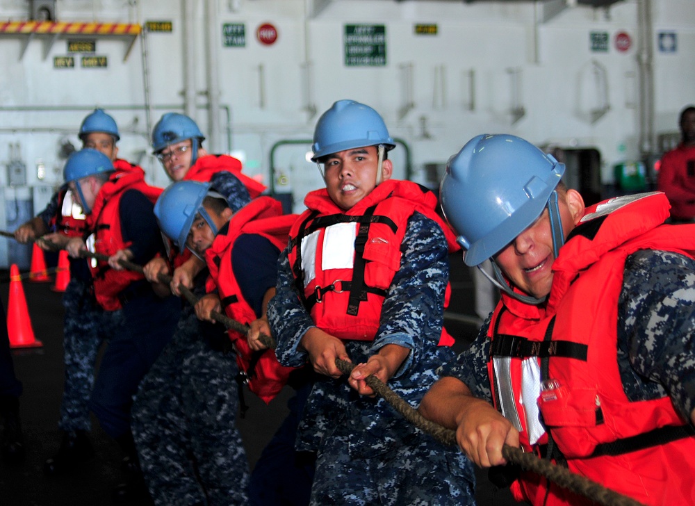 USS George Washington sailors heave on a line