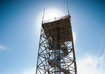 Airman stand in front of radar tower