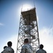 Airman stand in front of radar tower