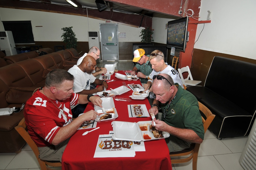 The judges for the '2012 Duty in Djibouti World Championship Barbeque Cooking Contest' sample the chicken from one of the eight contestants during the ultimate tailgate party