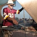 Construction Electrician 1st Class Cory Hinnant grills some ribs for his team the 'Can Do BBQ' during the ultimate tailgate party at Camp Lemonnier