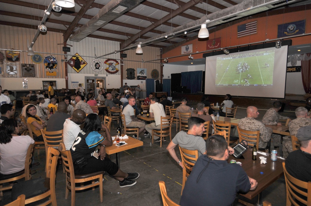 US military and civilian contractors watch the game between the Chicago Bears and the Indianapolis Colts during a tailgate party at Camp Lemonnier