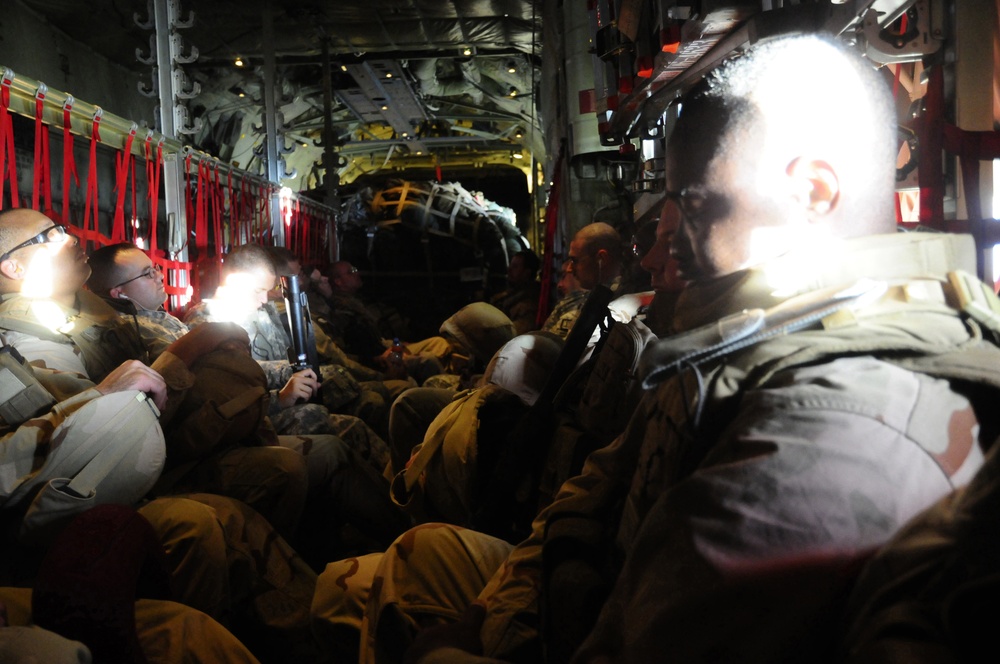 U.S. Navy Seabees fly aboard a C-130 Hercules aircraft