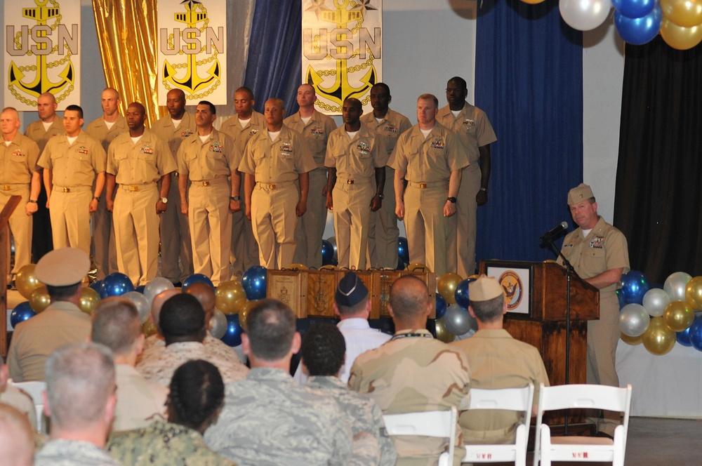 Camp Lemonnier commanding officer Capt. Kevin Bertelsen congratulates the chief petty officer selectees who are lined up on stage during the chief petty officer’s pinning ceremony at Camp Lemonnier
