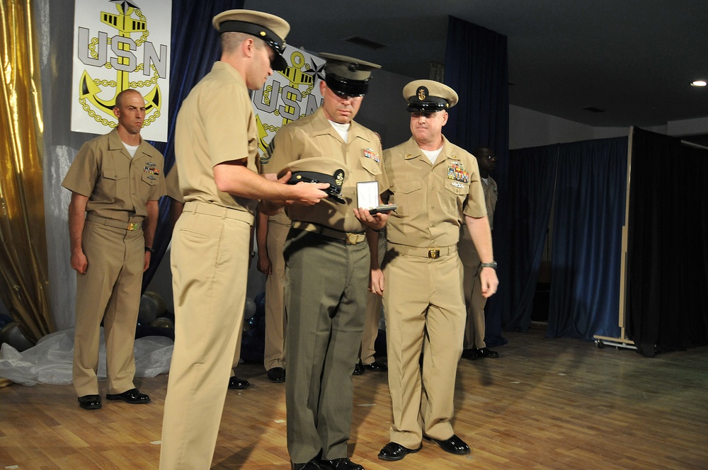 Honorary chief petty officer selectee Gunnery Sgt. Jerome Statema receives anchors and combination cover during the chief petty officer’s pinning ceremony at Camp Lemonnier