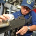 USS McCampbell sailor cleans machine gun