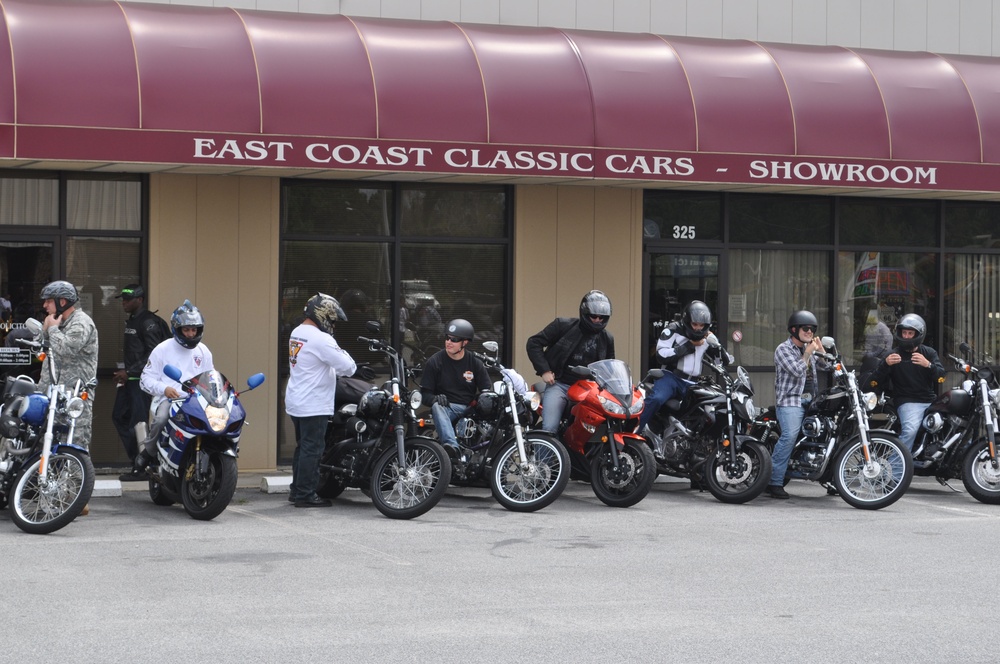 Motorcyclists tour vintage car showroom