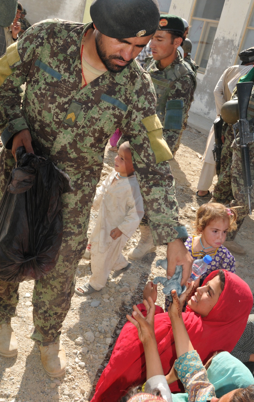 ANA, ISAF partner to hand out school supplies, continue progress in Zharay district