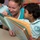Sailor reads with child during community service Sailor reads with child during community service