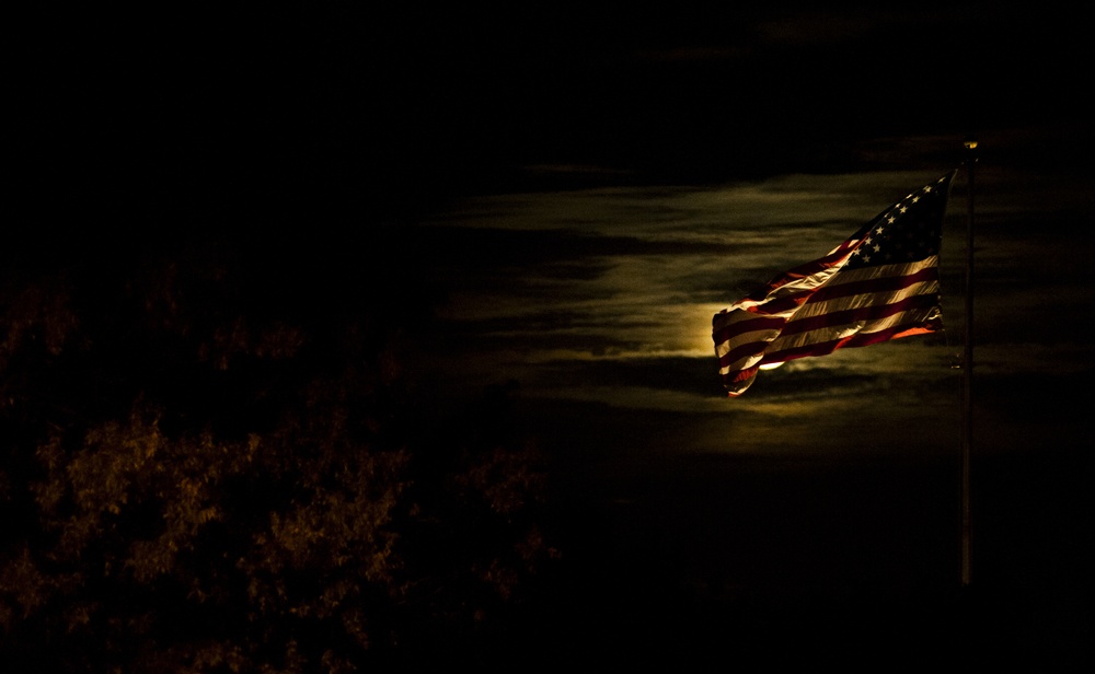American flag lit by a full moon