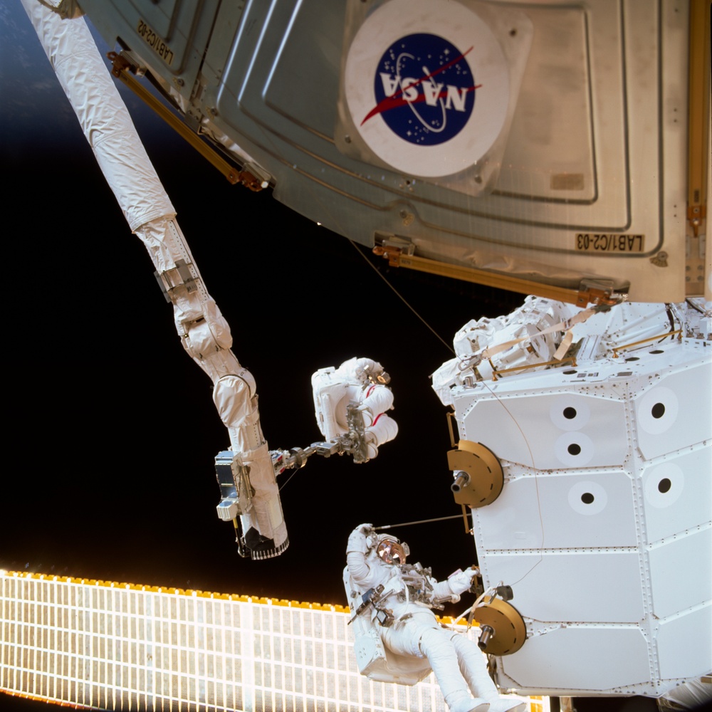 MS Hadfield and MS Parazynski work on the SSRMS from the SLP during an EVA for STS-100