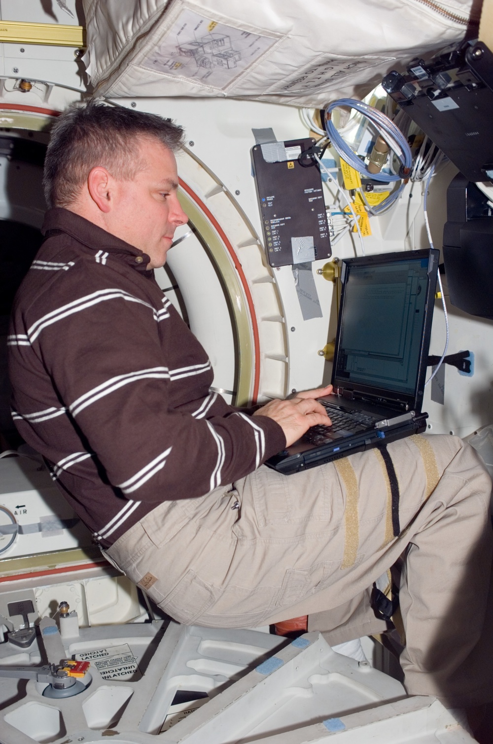 Johnson uses laptop computer near the A/L hatch in the MDDK during Joint Operations