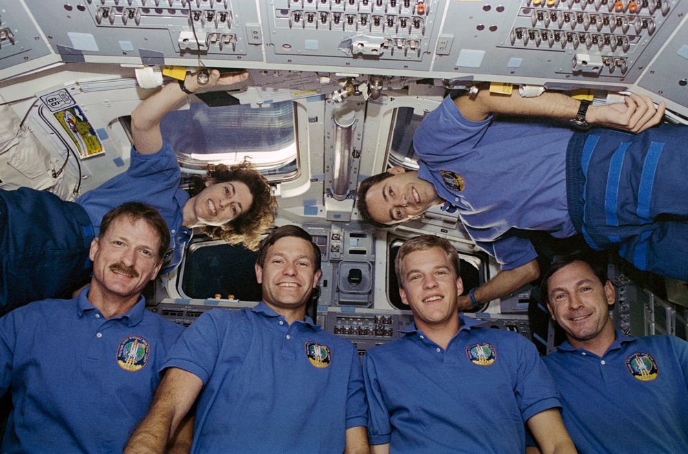 STS-66 crew portraits in front of Atlantis' flight deck windows