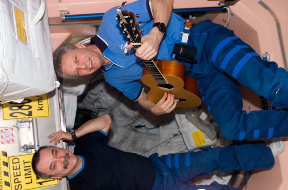 STS-116 FE Reiter plays guitar in the Node 1 during Joint Operations