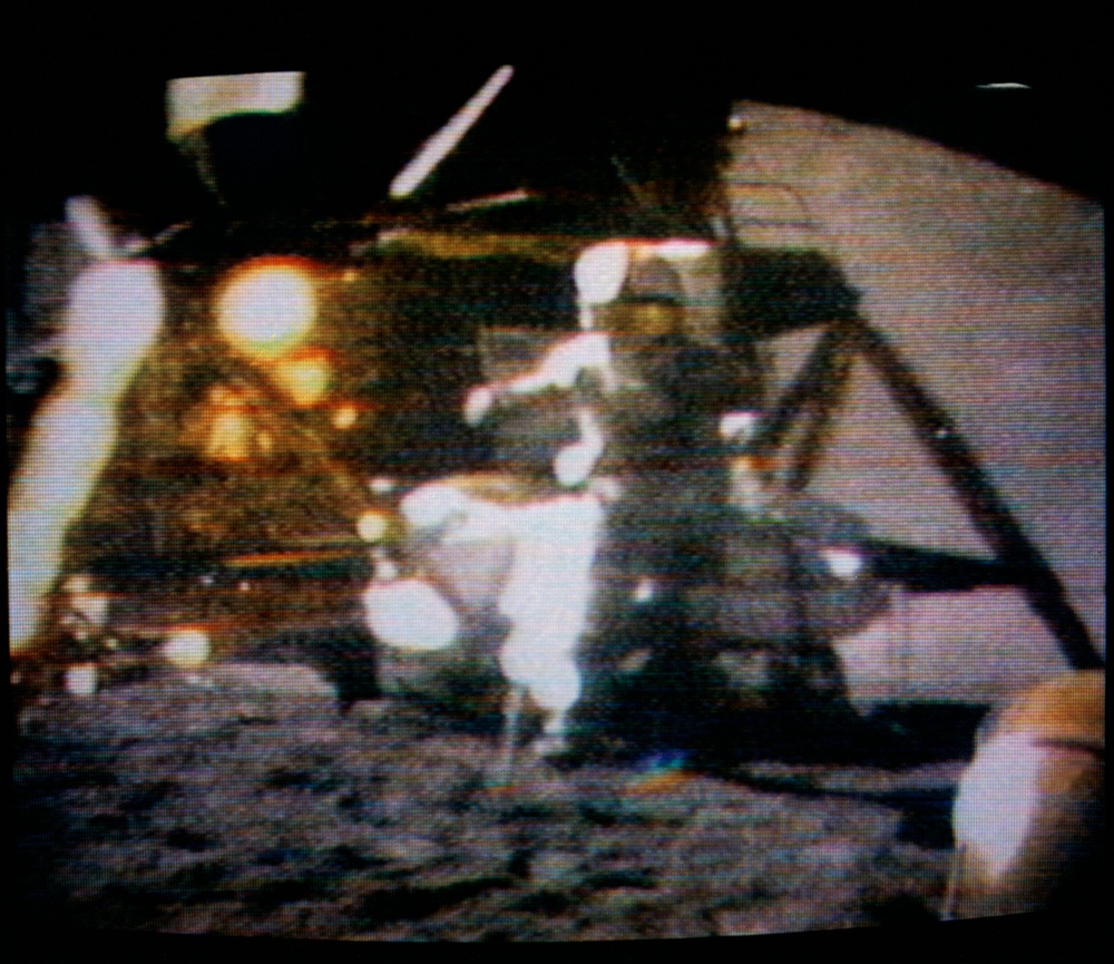 Astronaut David Scott watching hammer and feather fall to lunar surface