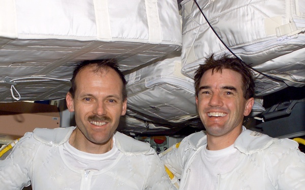 Walheim and Smith pose arm-in-arm in Node 1 after completing the first EVA for STS-110