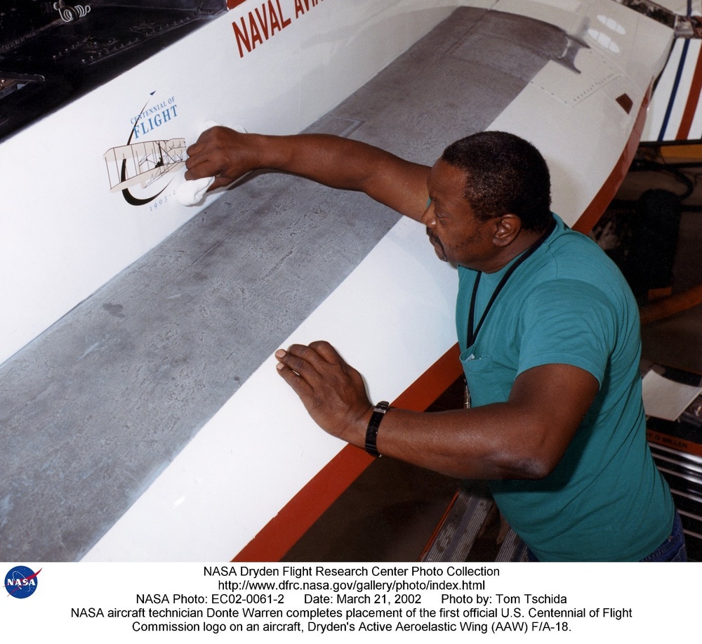 NASA aircraft technician Donte Warren completes placement of the first official U.S. Centennial of F