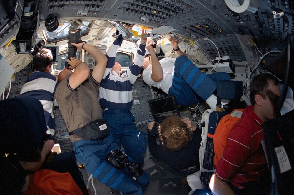 STS-101 crew taking photos during fly around