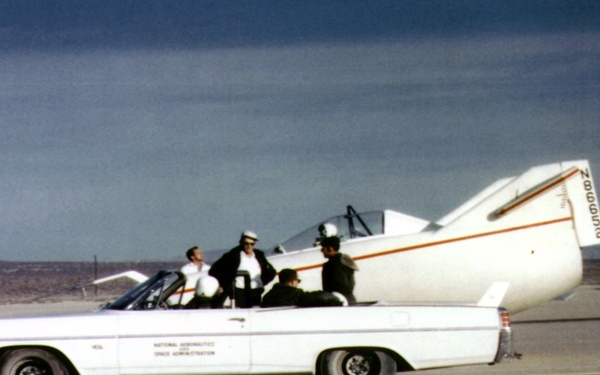 M2-F1 on lakebed with Pontiac convertible tow vehicle