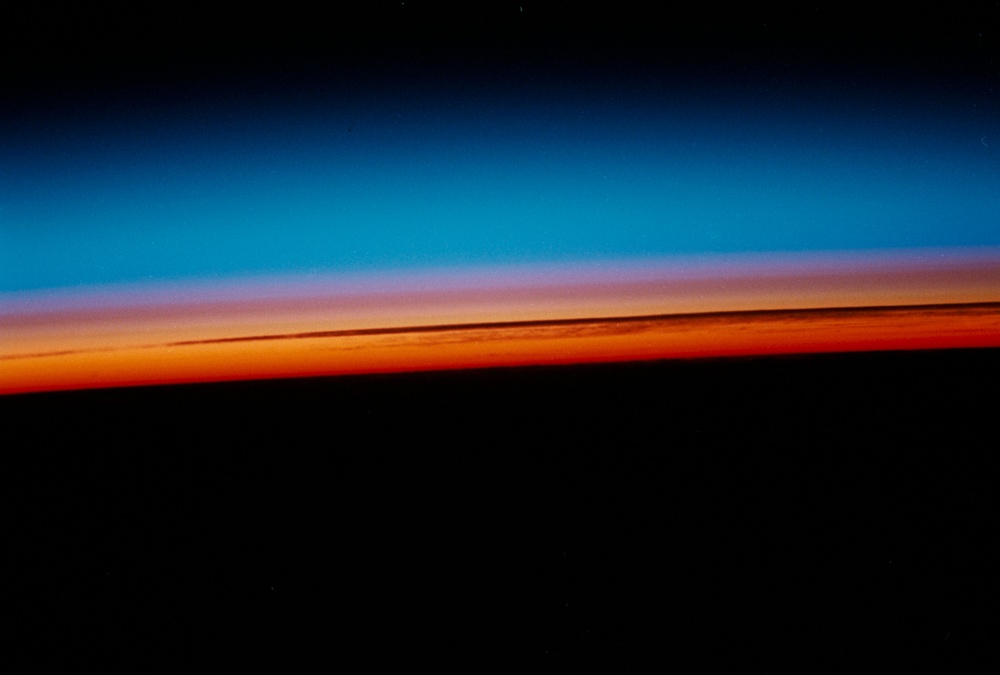 Sunrise and Earth Limb, high cirrus clouds silhouetted in the sun glow.