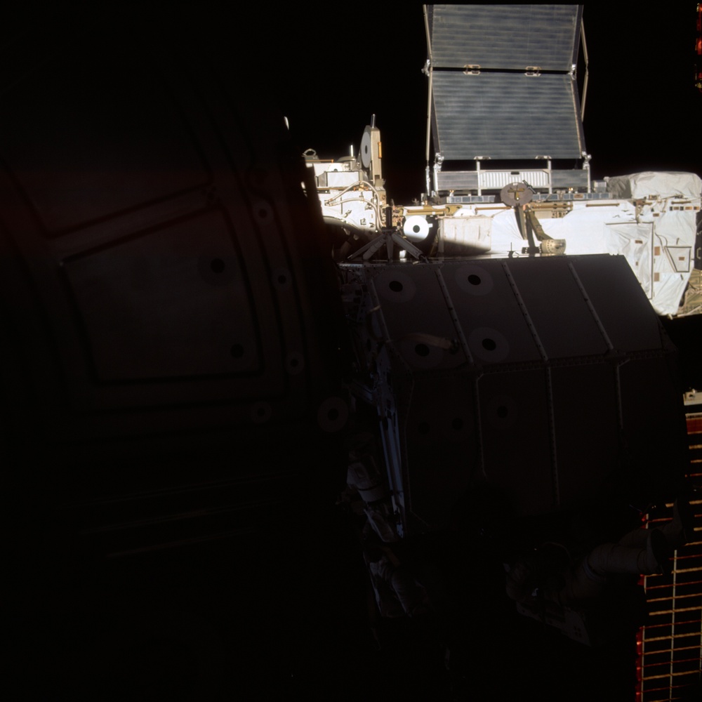 MS Hadfield and MS Parazynski work on the SSRMS from the SLP during an EVA for STS-100