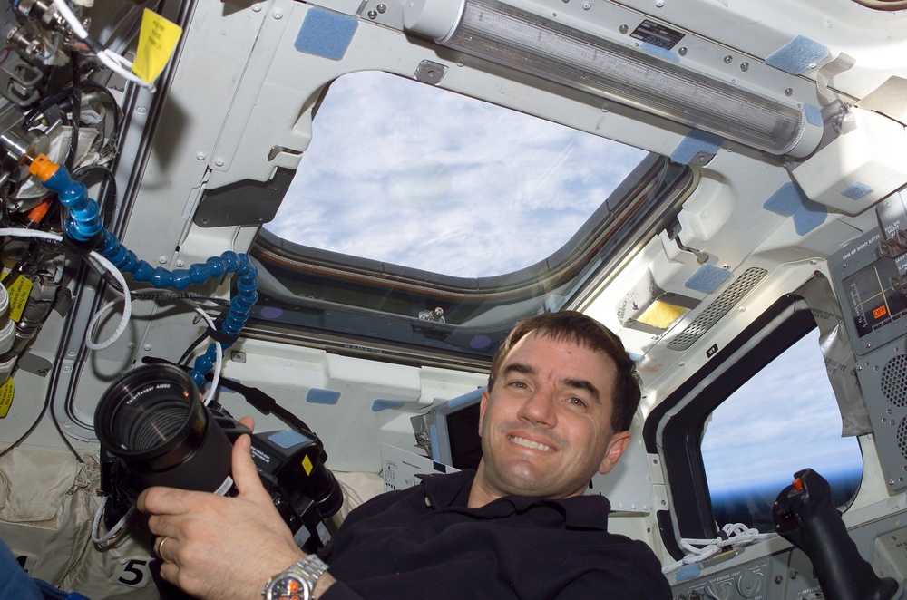 MS Walheim poses with a Hasselblad camera on the flight deck of Atlantis during STS-110