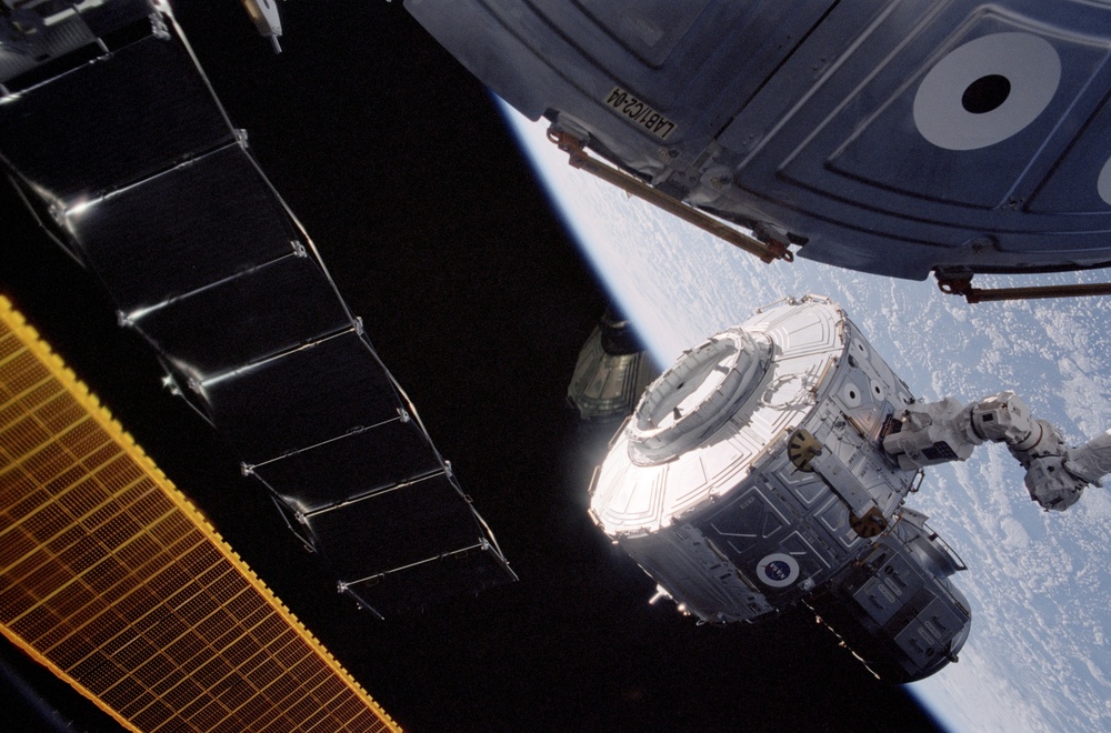 Quest airlock being maneuvered for installation during EVA 1