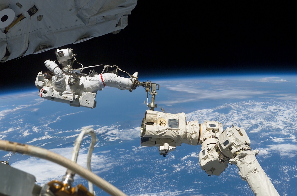 MS Ross is moved into position by the SSRMS during the fourth EVA of STS-110